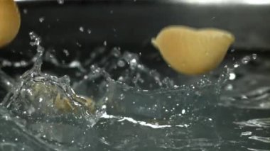 Makarna kaynar suya dökülüyor. 1000 fps 'de yüksek hızlı bir kamerayla çekildi. Yüksek kaliteli FullHD görüntüler