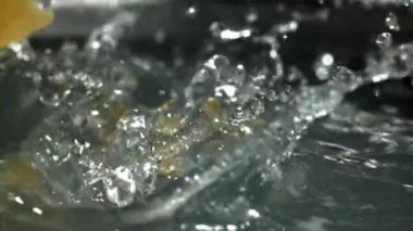 Farfalle makarnası kaynayan suya düşer. 1000 fps 'de yüksek hızlı bir kamerayla çekildi. Yüksek kaliteli FullHD görüntüler