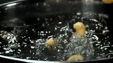 Makarna kaynar suya dökülüyor. 1000 fps 'de yüksek hızlı bir kamerayla çekildi. Yüksek kaliteli FullHD görüntüler