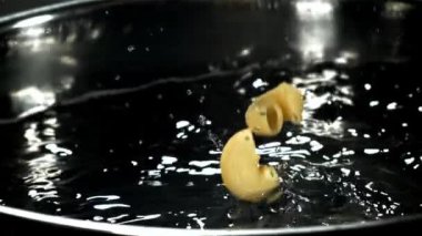 Makarna kaynar suya dökülüyor. 1000 fps 'de yüksek hızlı bir kamerayla çekildi. Yüksek kaliteli FullHD görüntüler