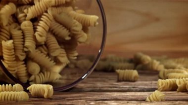 Fusili makarnası ahşap bir masaya düşer. 1000 fps 'de yüksek hızlı bir kamerayla çekildi. Yüksek kaliteli FullHD görüntüler
