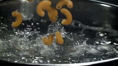 Makarna kaynar suya dökülüyor. 1000 fps 'de yüksek hızlı bir kamerayla çekildi. Yüksek kaliteli FullHD görüntüler