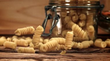 Fusili makarnası ahşap bir masaya düşer. 1000 fps 'de yüksek hızlı bir kamerayla çekildi. Yüksek kaliteli FullHD görüntüler
