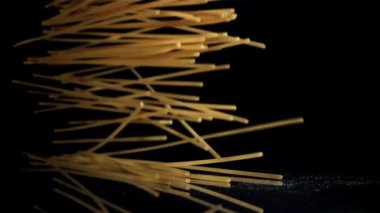 Siyah arka plana düşen kuru bir spagetti. 1000 fps 'de yüksek hızlı bir kamerayla çekildi. Yüksek kaliteli FullHD görüntüler