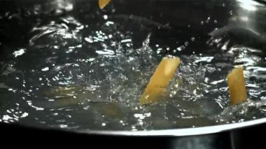 Makarna kaynayan suya düşer. 1000 fps 'de yüksek hızlı bir kamerayla çekildi. Yüksek kaliteli FullHD görüntüler
