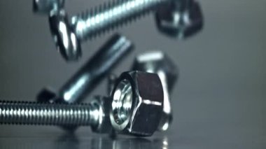 Metal bir masaya düşen somunlar, civatalar ve çamaşır makineleri. 1000 fps 'de yüksek hızlı bir kamerayla çekildi. Yüksek kaliteli FullHD görüntüler