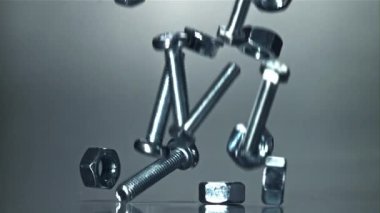 Metal bir masaya düşen somunlar, civatalar ve çamaşır makineleri. 1000 fps 'de yüksek hızlı bir kamerayla çekildi. Yüksek kaliteli FullHD görüntüler