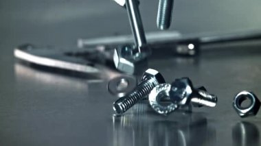 Metal bir masaya düşen somunlar, civatalar ve çamaşır makineleri. 1000 fps 'de yüksek hızlı bir kamerayla çekildi. Yüksek kaliteli FullHD görüntüler