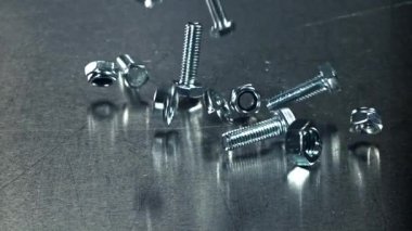 Metal bir masaya düşen somunlar, civatalar ve çamaşır makineleri. 1000 fps 'de yüksek hızlı bir kamerayla çekildi. Yüksek kaliteli FullHD görüntüler