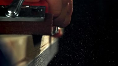 Bir marangoz ahşap bir kalas kumlar. 1000 fps 'de yüksek hızlı bir kamerayla çekildi. Yüksek kaliteli FullHD görüntüler