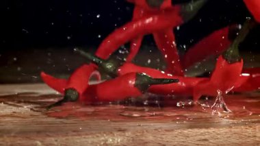 Kırmızı biberler masaya düşer. 1000 fps 'de yüksek hızlı bir kamerayla çekildi. Yüksek kaliteli FullHD görüntüler