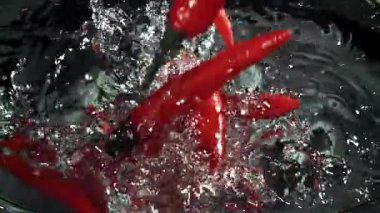 Kırmızı biberler suya düşer. 1000 fps 'de yüksek hızlı bir kamerayla çekildi. Yüksek kaliteli FullHD görüntüler
