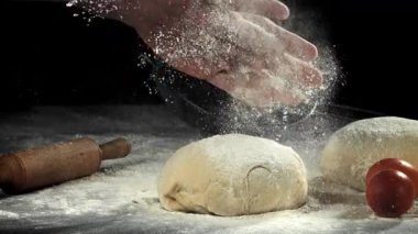 Un şefin ellerinden hamurun üzerine dökülür. 1000 fps 'de yüksek hızlı bir kamerayla çekildi. Yüksek kaliteli FullHD görüntüler