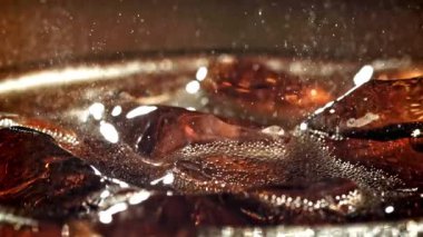 Bir bardak buzlu kola. Yüzeyde sıçramalar var. 1000 fps 'de yüksek hızlı bir kamerayla çekildi. Yüksek kaliteli FullHD görüntüler