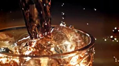Kola buzlu bir bardağa dökülür. 1000 fps 'de yüksek hızlı bir kamerayla çekildi. Yüksek kaliteli FullHD görüntüler