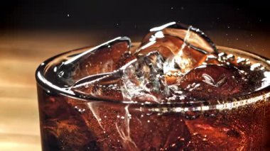 Bir bardak buzlu kola. Yüzeyde sıçramalar var. 1000 fps 'de yüksek hızlı bir kamerayla çekildi. Yüksek kaliteli FullHD görüntüler