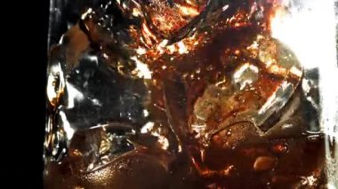 Kola buzlu bir bardağa dökülür. 1000 fps 'de yüksek hızlı bir kamerayla çekildi. Yüksek kaliteli FullHD görüntüler