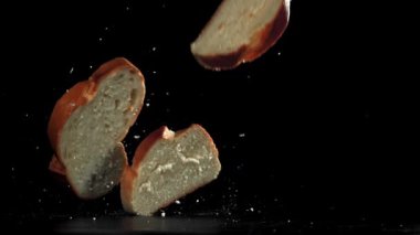 Ekmek parçaları siyah arka plana düşüyor. 1000 fps 'de yüksek hızlı bir kamerayla çekildi. Yüksek kaliteli FullHD görüntüler