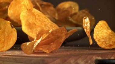 Patates cipsi ahşap masaya düşer. 1000 fps 'de yüksek hızlı bir kamerayla çekildi. Yüksek kaliteli FullHD görüntüler
