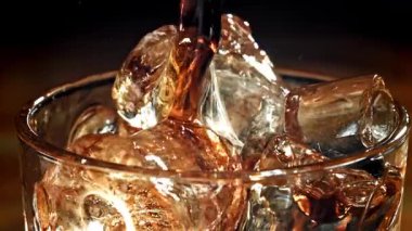 Kola buzlu bir bardağa dökülür. 1000 fps 'de yüksek hızlı bir kamerayla çekildi. Yüksek kaliteli FullHD görüntüler