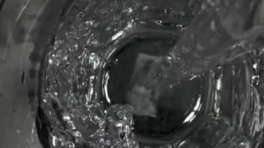 Su bir bardağa doldurulur. 1000 fps 'de yüksek hızlı bir kamerayla çekildi. Yüksek kaliteli FullHD görüntüler