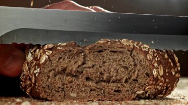 Şef taze ekmek dilimler. 1000 fps 'de yüksek hızlı bir kamerayla çekildi. Yüksek kaliteli FullHD görüntüler