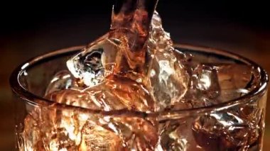 Kola buzlu bir bardağa dökülür. 1000 fps 'de yüksek hızlı bir kamerayla çekildi. Yüksek kaliteli FullHD görüntüler