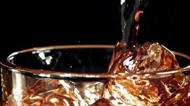 Kola buzlu bir bardağa dökülür. 1000 fps 'de yüksek hızlı bir kamerayla çekildi. Yüksek kaliteli FullHD görüntüler