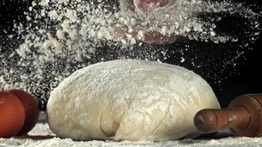 Şef hamura un serper. 1000 fps 'de yüksek hızlı bir kamerayla çekildi. Yüksek kaliteli FullHD görüntüler