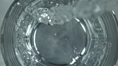Su bir bardağa doldurulur. 1000 fps 'de yüksek hızlı bir kamerayla çekildi. Yüksek kaliteli FullHD görüntüler