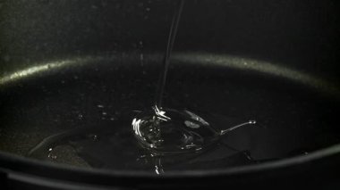 Yağ kızartma tavasına dökülüyor. 1000 fps 'de yüksek hızlı bir kamerayla çekildi. Yüksek kaliteli FullHD görüntüler