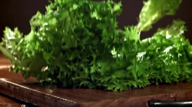 Marul kesme tahtasına düşer. 1000 fps 'de yüksek hızlı bir kamerayla çekildi. Yüksek kaliteli FullHD görüntüler