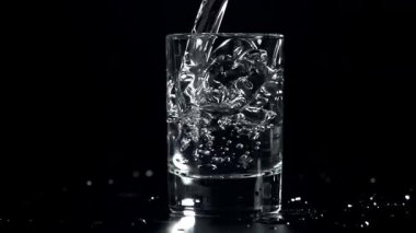Bardakta soğuk votka. 1000 fps 'de yüksek hızlı bir kamerayla çekildi. Yüksek kaliteli FullHD görüntüler