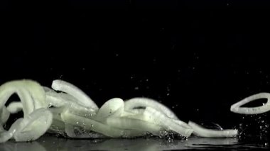 Dilimlenmiş soğan halkaları ıslak masaya düşer. 1000 fps 'de yüksek hızlı bir kamerayla çekildi. Yüksek kaliteli FullHD görüntüler