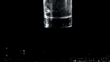 Bardakta votka masaya düşer. 1000 fps 'de yüksek hızlı bir kamerayla çekildi. Yüksek kaliteli FullHD görüntüler