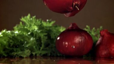Soğan ıslak bir kesme tahtasına düşer. 1000 fps 'de yüksek hızlı bir kamerayla çekildi. Yüksek kaliteli FullHD görüntüler