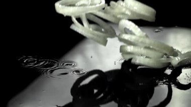 Dilimlenmiş soğan halkaları ıslak masaya düşer. 1000 fps 'de yüksek hızlı bir kamerayla çekildi. Yüksek kaliteli FullHD görüntüler