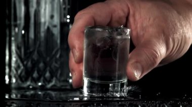 Adam masaya bir bardak votka koyar. 1000 fps 'de yüksek hızlı bir kamerayla çekildi. Yüksek kaliteli FullHD görüntüler