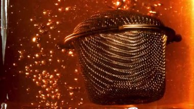 Sıcak suda çay demlemek için süzgeç. 1000 fps 'de yüksek hızlı bir kamerayla çekildi. Yüksek kaliteli FullHD görüntüler