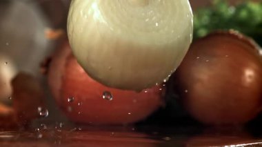 Soğan ıslak bir kesme tahtasına düşer. 1000 fps 'de yüksek hızlı bir kamerayla çekildi. Yüksek kaliteli FullHD görüntüler