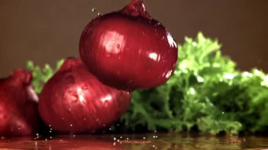 Soğan ıslak bir kesme tahtasına düşer. 1000 fps 'de yüksek hızlı bir kamerayla çekildi. Yüksek kaliteli FullHD görüntüler