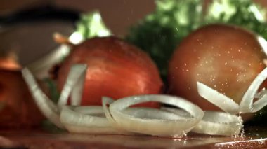 Doğranmış soğan kesme tahtasına düşer. 1000 fps 'de yüksek hızlı bir kamerayla çekildi. Yüksek kaliteli FullHD görüntüler