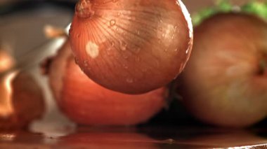 Soğan ıslak bir kesme tahtasına düşer. 1000 fps 'de yüksek hızlı bir kamerayla çekildi. Yüksek kaliteli FullHD görüntüler