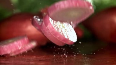Doğranmış soğan kesme tahtasına düşer. 1000 fps 'de yüksek hızlı bir kamerayla çekildi. Yüksek kaliteli FullHD görüntüler