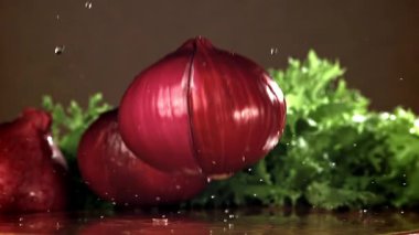 Soğan ıslak bir kesme tahtasına düşer. 1000 fps 'de yüksek hızlı bir kamerayla çekildi. Yüksek kaliteli FullHD görüntüler