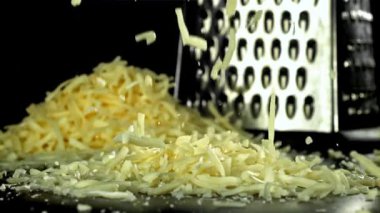 Rendelenmiş peynir masaya düşer. 1000 fps 'de yüksek hızlı bir kamerayla çekildi. Yüksek kaliteli FullHD görüntüler