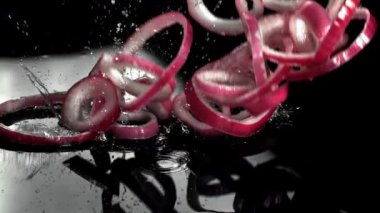 Dilimlenmiş soğan halkaları ıslak masaya düşer. 1000 fps 'de yüksek hızlı bir kamerayla çekildi. Yüksek kaliteli FullHD görüntüler