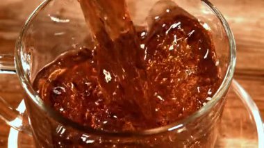 Siyah çay fincana dökülür. 1000 fps 'de yüksek hızlı bir kamerayla çekildi. Yüksek kaliteli FullHD görüntüler