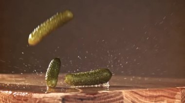 Salatalık turşusu ahşap bir masaya düşer. 1000 fps 'de yüksek hızlı bir kamerayla çekildi. Yüksek kaliteli FullHD görüntüler
