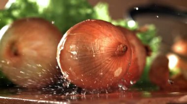 Soğan ıslak bir kesme tahtasına düşer. 1000 fps 'de yüksek hızlı bir kamerayla çekildi. Yüksek kaliteli FullHD görüntüler